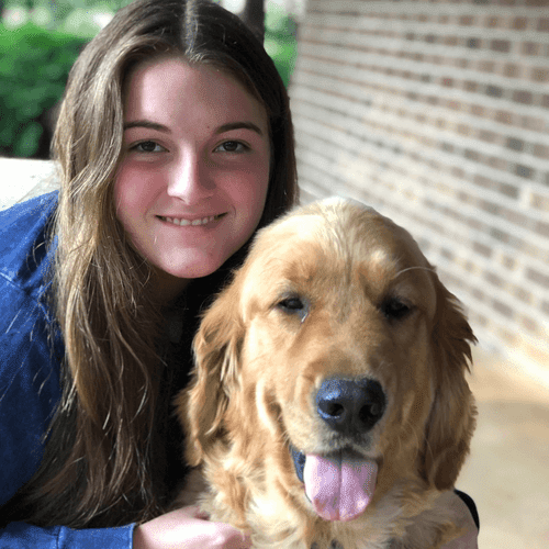 Haley posing for a photo with a golden retriever